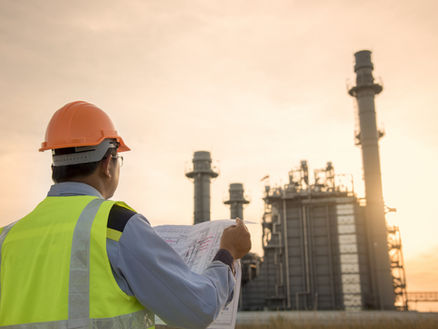 Engineer Looking At Blueprint On Site