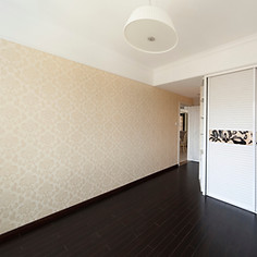 An empty room with a wallpapered wall