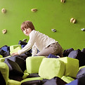 An indoor climbing soft play area with a child climbing