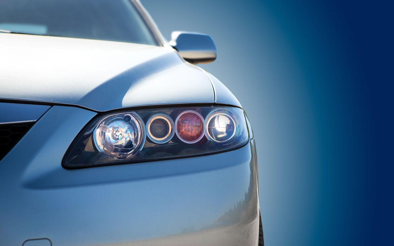 Front of a white car with bright headlight