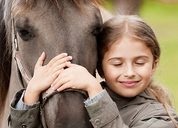 Mädchen umarmt Pferd