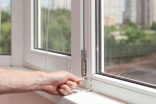 Handyman repairs plastic window with a hexagon. Workman adjusts the operation of the plast