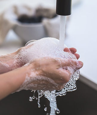 Hands washing under faucet