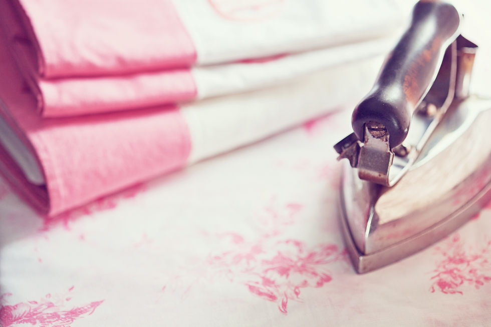 Vintage iron on pink floral sheet, pink linens by it's side