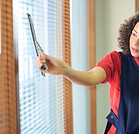 Office cleaner cleaning blinds