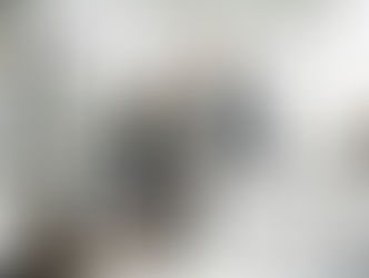 A man and woman smiling while unloading the dishwasher.