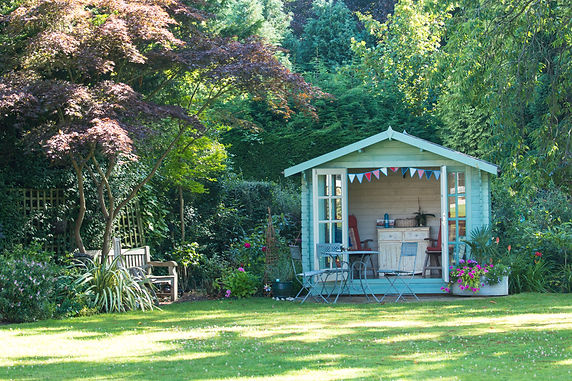 Summer in the garden on a sunny day with the summer house with the doors open