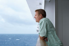 Guest on a cruise balcony looking out to sea