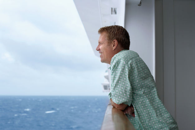 Guest on a cruise balcony looking out to sea