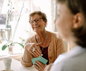 Older woman playing card with companions