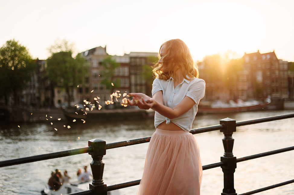 Background of Woman by stream with flower petals floating out of her hands