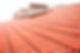 Overlapping rows of red tiles roof with chimneys