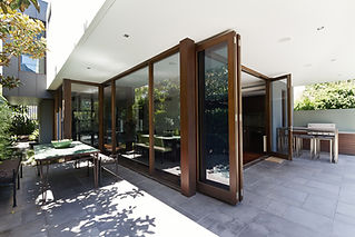 A set of brown-framed bi-fold doors leading to a patio.
