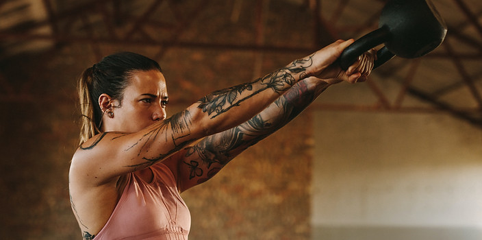 Frau hebt Kettlebell