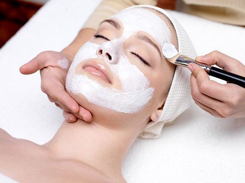 Beautiful woman with facial mask at beauty salon