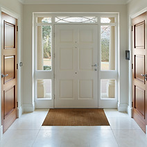 Circular image showing an interior view of a bright white front door entrance hallway with side window panels