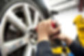 Detail image of mechanic hands with tool, changing tyre of car, with blurred background of