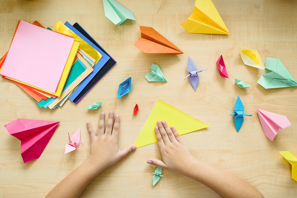 Colourful origami paper and crafting tools arranged on a table