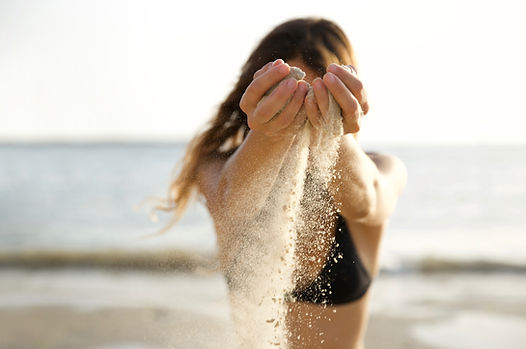 Les mains qui versent le sable