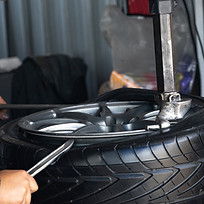 Car mechanic installing sensor during suspension adjustment