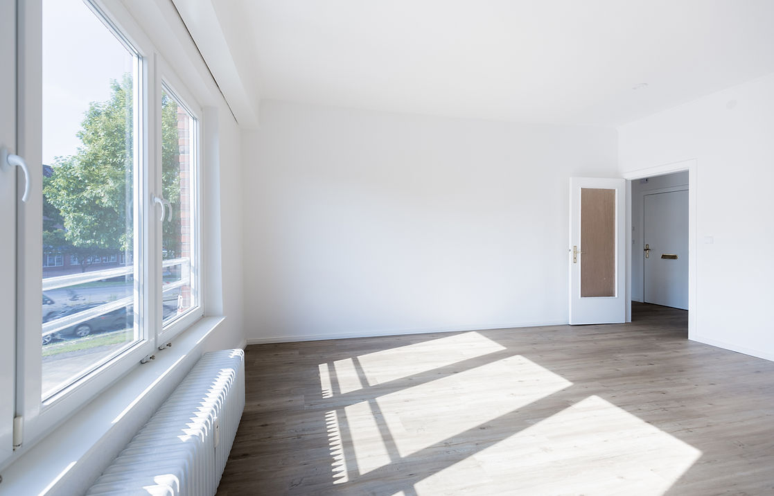 Bright, empty room with white walls and light wood flooring