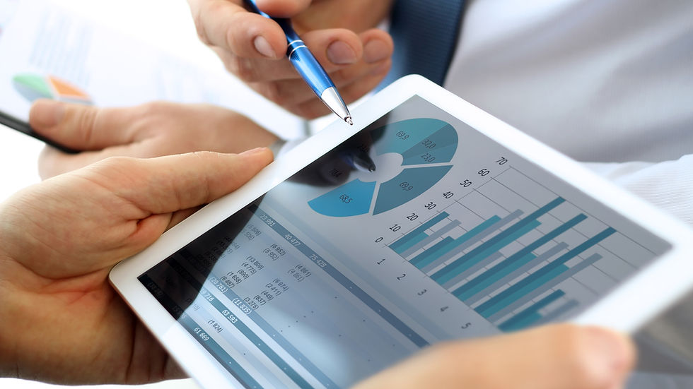 Hands hold a tablet displaying a pie and bar chart, with a person pointing at the screen with a pen. Data analysis concept.