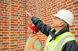 workers in hard hats and safety vests inspecting site