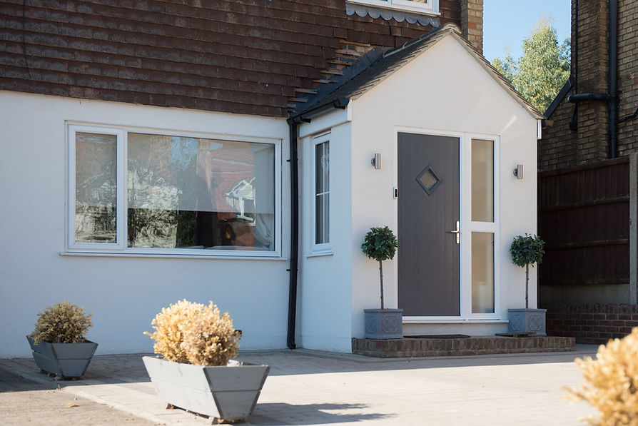 A general exterior view of a porch with a grey composite front door and uPVC windows