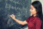 A teacher writing on a blackboard