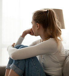 Image of woman looking out the window contemplating.