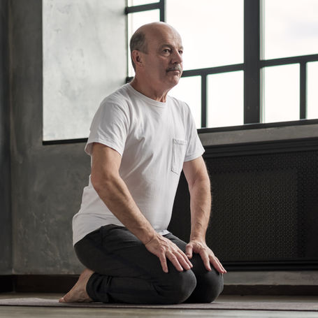 Man kneeling stretching Pilates