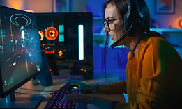 Person with headphone sitting at a desk looking at a computer screen