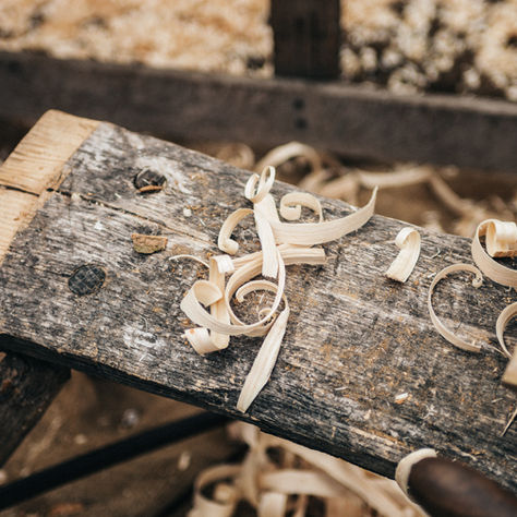 Ein Holzbrett in einer Werkstatt mit Holzspähnen.