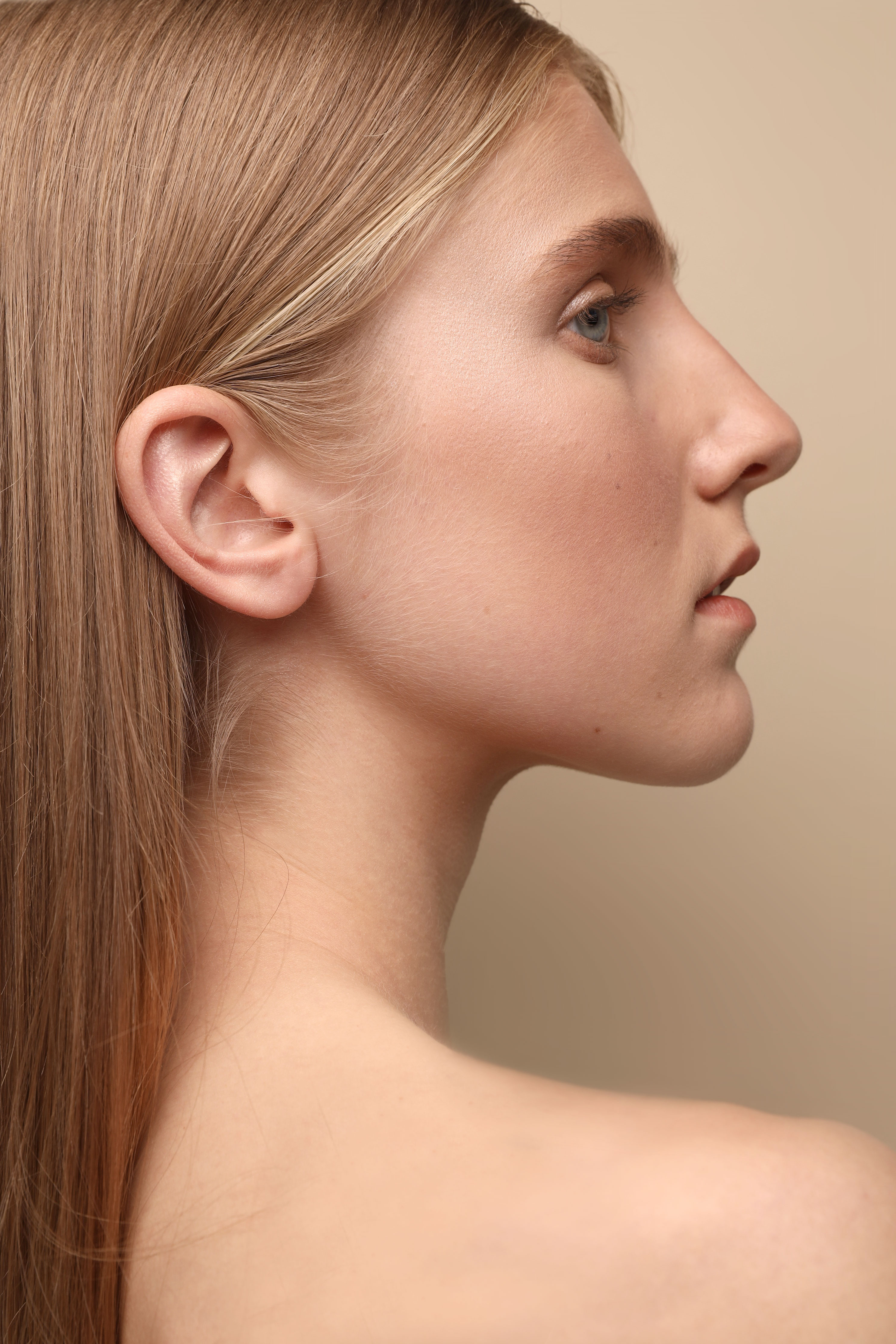 Close-up of a woman’s face with clear skin, leading to the Luxient face care product list.