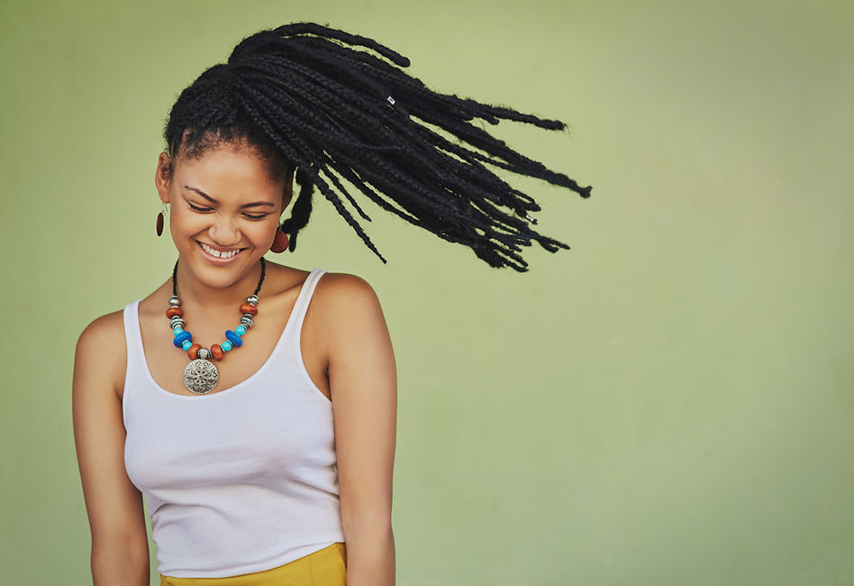 A woman has her dreads tied in a ponytail.