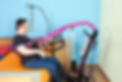 Young man with cerebral palsy sitting on sofa next to machine
