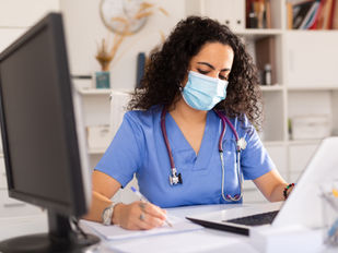 Nurse handling computer and documents