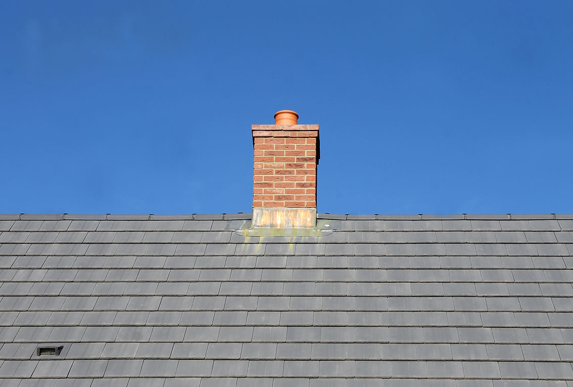 House roof and chimney under blue sky