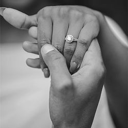 Couple holding hands, showcasing engagement ring