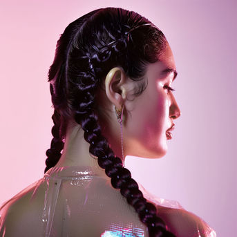 Woman with sleek double braids in pink studio lighting