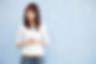 Woman in tee-shirt and jeans in front of a light blue wall