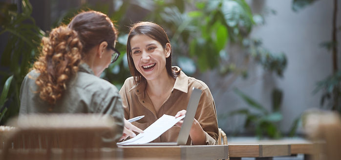 Meeting between female client and occupational therapist outside at a cafe