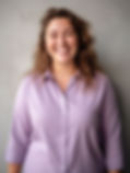 Smiling woman with curly hair in a purple shirt