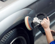 Close-up of hands worker using polisher to polish a car body in the workshop