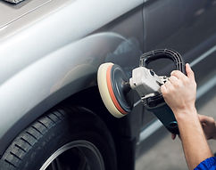 Close-up of hands worker using polisher to polish a car body in the workshop