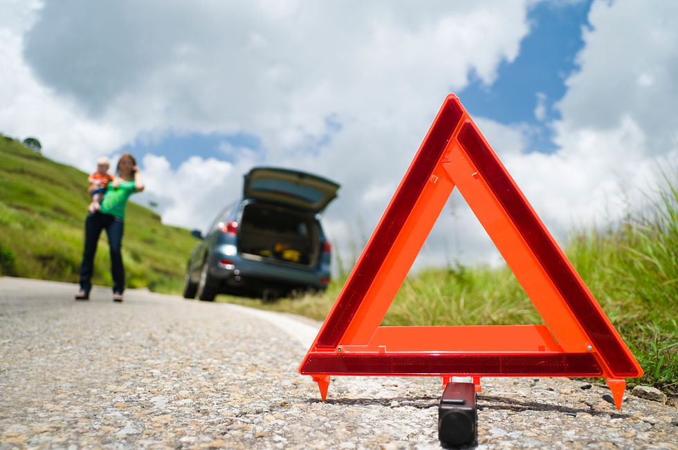 Woman with child on roadside with warning triangle placed on road