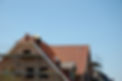 Roofers installing new roof of house under construction