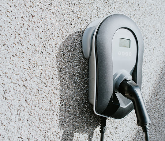 An electric car charger mounted on the exterior wall of a domestic house