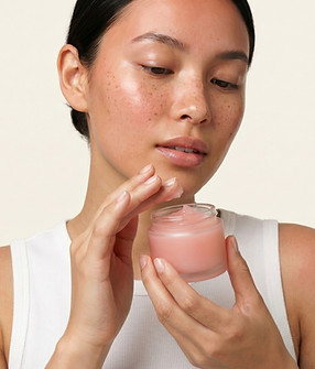 Natural emollients for creams and lotions: woman holding a jar of moisturiser