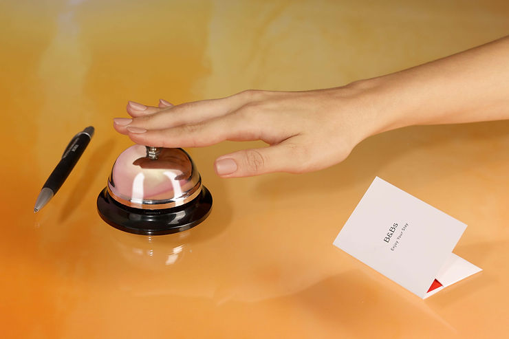 Expresiones Útiles en Francés para Hoteles: Guía Completa para Viajeros 🏨✈️ 1 una persona tocando la campana de recepción de un hotel